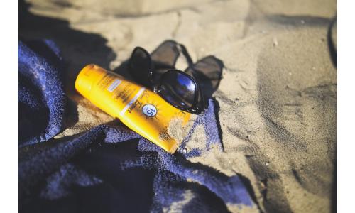 Slnečný krém na pláži so štýlovými okuliarmi