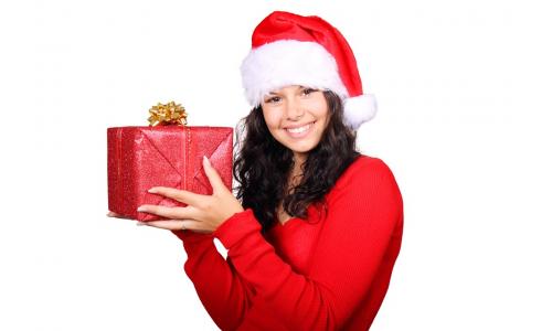 Žena vo vianočnej čiapke s darčekom