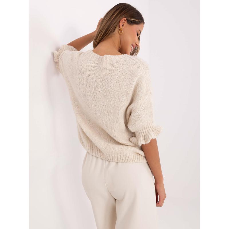 Világos bézs színű pulóver fodrokkal az ujjakon