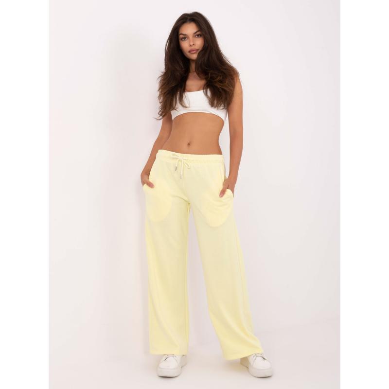 Světle žluté tepláky s kapsami